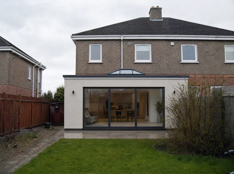 After: the same house with a single-storey rendered rear extension, roof lantern and sliding doors