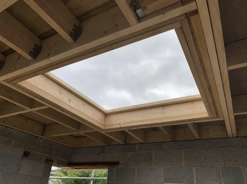 Flat-roof joists with a trimmed opening for a roof lantern on a new extension