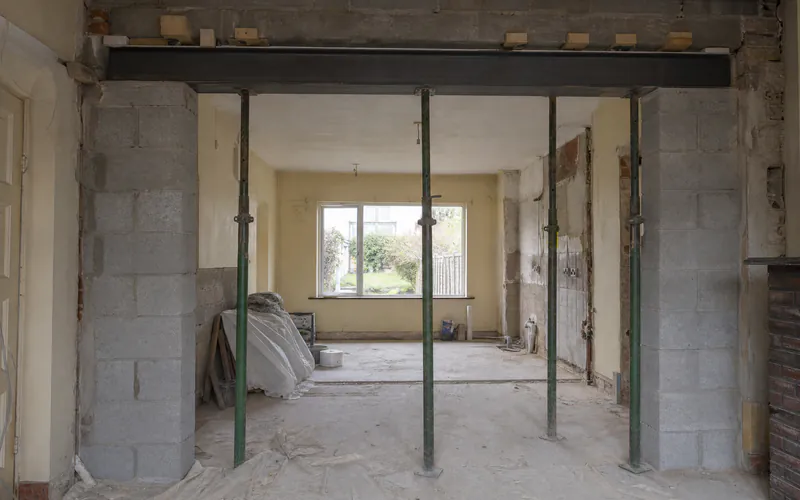 New steel beam on concrete padstones across a kitchen knock-through in a Dublin semi, props still in place
